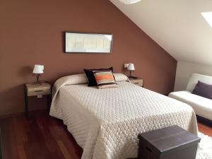 a bedroom with a bed and two night stands with lamps at Rego de Flores in Viveiro