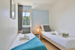 two beds in a room with a window at ღ L'Oasis du Golf - Paisible maison proche Mer in Talmont +20 photos