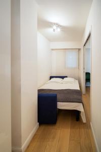 a bedroom with a bed and a blue chair at Sunny Days in Nice