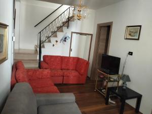 a living room with a red couch and a staircase at Appartamento Santacroce in Pratola Peligna