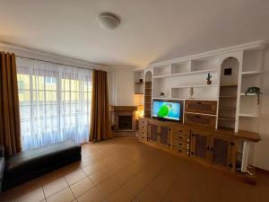 a living room with a tv on a entertainment center at Centro Toscal 3 dorm Patio Cocina in Los Realejos
