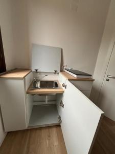 a small white kitchen with a sink in it at Luminoso alloggio sul mare in Cattolica