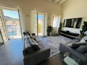 a living room with two couches and a television at Luxury Seafront Penthouse in Porto Azzurro