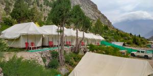 a row of tents in front of a mountain at Camp Paramount Journeys in Jispa