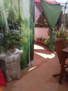 a patio with a statue of a woman with a plant at ONLY4MAN luxury Guesthouse Sitges in Sitges