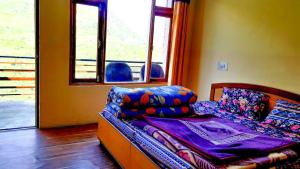 a small bed in a room with a window at Pine Corn Guest House in Kyelang