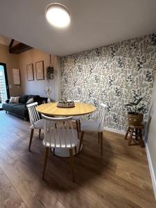 a living room with a table and white chairs at L'arbre de soie Futuroscope Acacia in Vouillé +41 photos