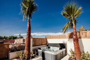 a hot tub on a balcony with two palm trees at Riad Enchanté in Marrakech