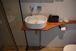 a white sink on a wooden counter in a bathroom at van Harte in Zeeland in Kamperland +14 photos