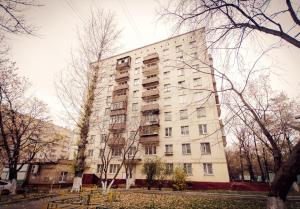 モスクワにあるStudio Apartmentの白い高い建物の前に木々