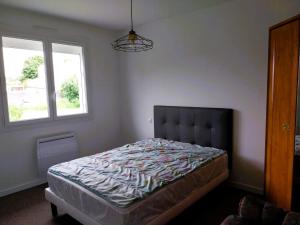a bedroom with a bed in a room with a window at La Maison du Verger in Sainte-Foy
