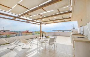 eine Terrasse mit Tisch und Stühlen auf einem Balkon in der Unterkunft Gorgeous Home In Marina Di Ragusa in Marina di Ragusa