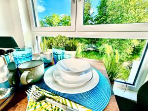 a table with a bowl and plates and a window at Urlaub am See in Görtschach