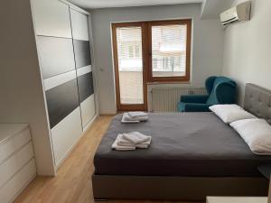 a bedroom with a bed and a blue chair at BT Lux apartment 2 in Skopje