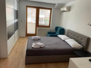 a bedroom with a bed and a blue chair at BT Lux apartment 2 in Skopje