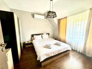 a bedroom with a bed with white sheets and a window at Апартамент Свети Влас in Sveti Vlas