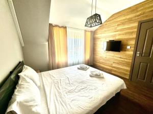 a bedroom with a white bed and a television at Апартамент Свети Влас in Sveti Vlas