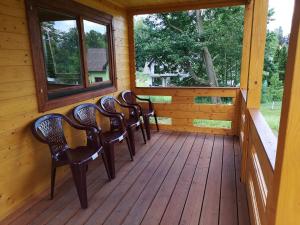 a porch of a cabin with chairs and a window at Janowickie Zacisze in Janowice Wielkie