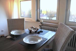 a dining room table with two plates and two windows at Ferienwohnung Stellberg in Homberg