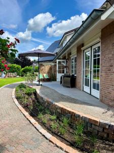 a brick house with a patio and an umbrella at De Bonte Specht in Nijverdal