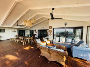 a living room with couches and a dining room at 4 Bedroom Beach House on 4th Ave in Umdloti