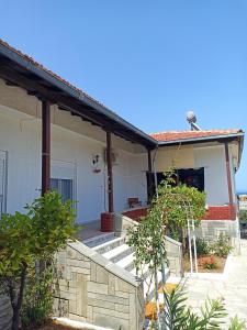 a white house with a porch and a door at Kalelia in Nea Potidaea +13 photos