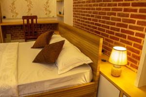 a bed in a room with a brick wall at Nhucasa Studio Apartment in Pātan +25 photos