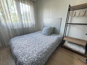 a small bedroom with a bed and a window at La Maison du Bonheur in Saint-Herblain