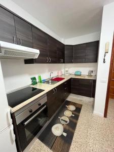 a kitchen with wooden cabinets and a sink at Toscal centro 3 dorm Balcón Cocina in Los Realejos +8 photos