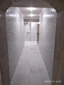 a bathroom with a walk in shower and a tile hallway at Hotel Caesars Palace in Sunny Beach