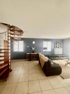 a large room with a bed and a spiral staircase at Villa Coustete in Bôo-Silhen