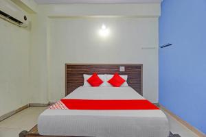 a bedroom with a large bed with red pillows at Hotel O Satya Inn in Karīmnagar +23 photos