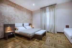 a hotel room with two beds and a window at VITTORIA ROOMS GuestHouse - the Original since 2015 in Genoa