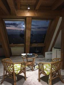 a room with two chairs and a table and two windows at Charmantes Dachloft mit spektakulärer Aussicht in Ludwigsburg