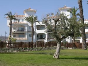 een wit huis met palmbomen ervoor bij Hacienda Golf Resort - 1508 in Sucina