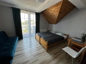 a bedroom with a bed and a couch and a table at Odyseusz Jastarnia in Jastarnia