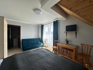 a bedroom with a blue bed and a blue couch at Odyseusz Jastarnia in Jastarnia