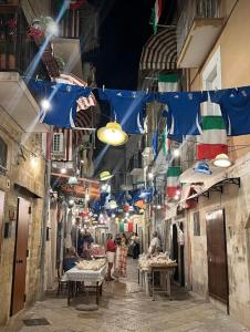 an alley with flags and people in a street at La Casa delle Tradizioni in Bari