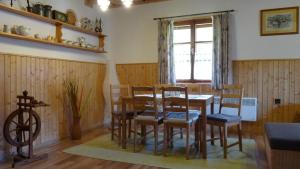 a dining room with a table and chairs and a window at Chata IVA in Oščadnica