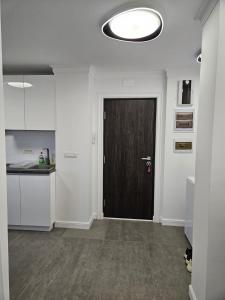a hallway with a black door in a white room at Apartament pe malul Mureșului in Arad +19 photos