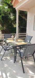 einen Tisch und zwei Stühle auf einer Terrasse in der Unterkunft Villa Kiki by the beach! in Kókkinon Nerón