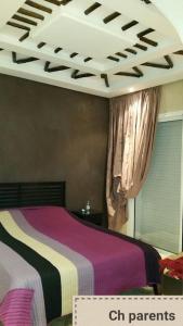 a bedroom with a bed with purple and colorful sheets at Villa, piscine sans vis-à-vis in Casablanca +17 photos