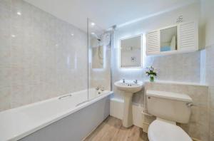 a bathroom with a sink and a toilet and a bath tub at N ° 42 The Salcombe in Salcombe