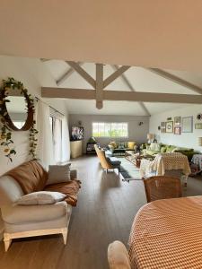 a large living room with a couch and chairs at Jolie Villa en bois au calme in Arès