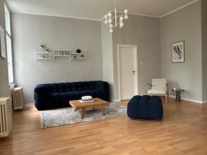 a living room with a blue couch and a table at Ferienwohnungen Leipzig Musikviertel Zentrum Süd - zentral und dennoch ruhig in Leipzig