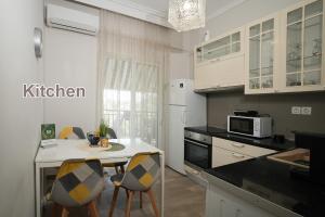 a kitchen with a table and chairs and a microwave at Golden Beach Apartment in Nea Moudania
