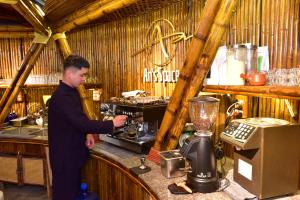 a man standing at a counter in a bar with a blender at An's Space Sapa in Lao Cai