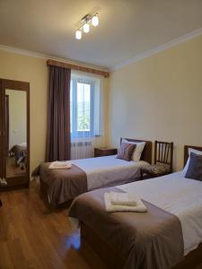 ein Hotelzimmer mit zwei Betten und einem Spiegel in der Unterkunft Zartonq in Tatev + 26 Fotos