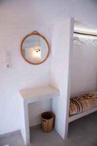 a mirror on a wall next to a white table at Ostria kythnos apartment in Kithnos