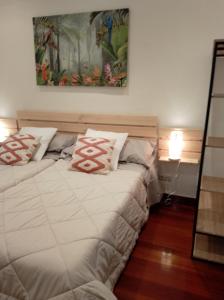 una camera da letto con due letti e un dipinto sul muro di Centro de Bilbao, amplio, ascensor a Bilbao